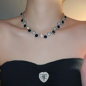 Detailed view of luxury geometric necklace with alternating black stones and silver crystals