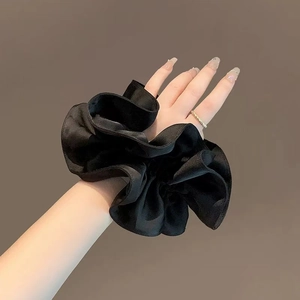 Elegant black satin large scrunchie hair tie on model wrist with minimalist style