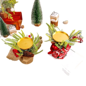 Christmas candle holder with red berries, pine cones and pine needles on golden metal tray