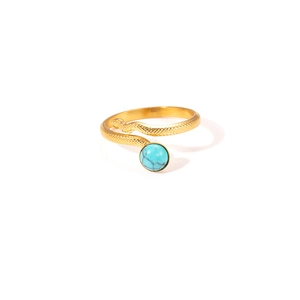 Detailed shot of golden snake ring with scales and inlaid turquoise stone on white background