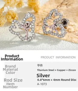 Macro shot of silver bow rabbit cartilage earring with white zircons and pink enamel details