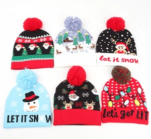Detailed flat lay of six Christmas knit beanies with reindeer patterns and pom-poms