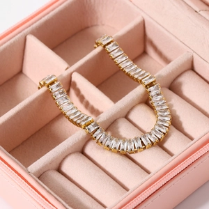 Lussuoso bracciale placcato oro con zirconi rettangolari in un portagioie rosa