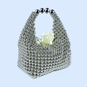 Detail shot of handcrafted silver beaded pillow bag with metallic luster and satin lining