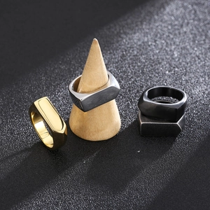 Dettaglio di anelli geometrici in acciaio inossidabile in nero, oro, argento e grigio