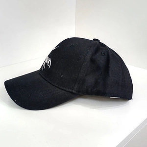 Close-up of white embroidery detail on a black cotton six-panel baseball cap