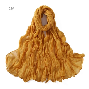 Detailed texture of yellow pleated linen-feel scarf showing soft breathable gauze fabric