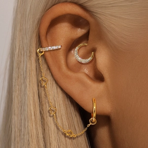 Close-up of golden S925 silver chain earrings with heart pendant and sparkling zircons