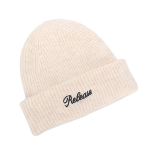 Detailed view of cream-colored knit beanie with black Release embroidery text