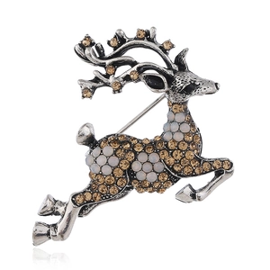 Détail macro d'une broche renne en argent vintage avec strass ambre et opale