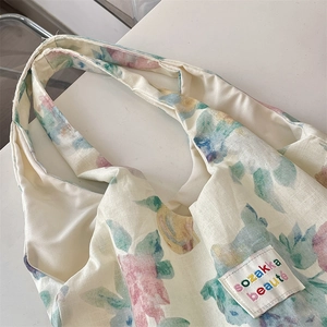 Close-up of floral linen tote bag featuring watercolor flower patterns and textile label