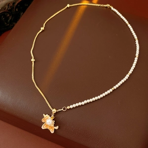 Detail of fox pendant necklace featuring gold chain and white faux pearl beads