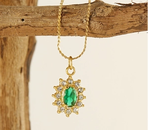 Macro detail of sunflower pendant with green zircon stone and gold plated setting
