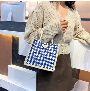 Detailed view of blue houndstooth canvas bag showing rope handles and button closure