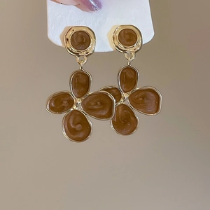 Détails rapprochés de boucles d'oreilles vintage en émail brun et plaqué or