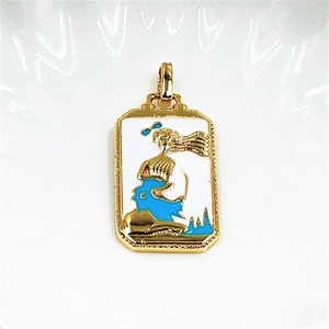 Macro shot of gold-plated tarot pendant with blue mermaid art and white enamel inlay