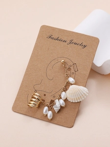 Detailed view of bohemian earrings with shells and pearls on jewelry card display
