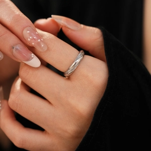 Close-up of twisted silver-tone ring with pavé zircon setting on hand