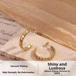 Detailed view of gold C-shaped woven twist hoop earrings with vacuum plating on stone base