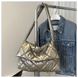 Detail view of metallic silver quilted shoulder bag with soft padded puffer texture
