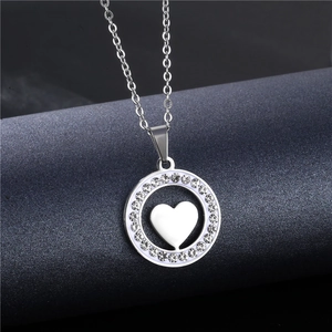 Detailed close-up of a silver heart pendant necklace with shimmering white rhinestones
