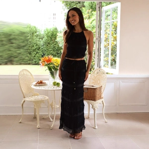 Elegant black two-piece chiffon set featuring a halter top and tiered maxi skirt