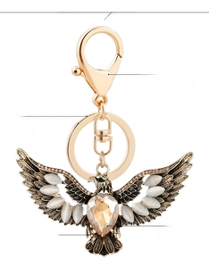 Macro detail of golden eagle keychain with cat eye stone and amber heart rhinestone