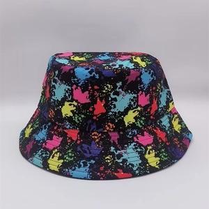 Detail showing neon paint splatter pattern on a black fisherman bucket hat