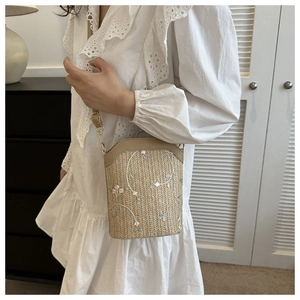 Sac seau en paille avec broderies florales et bandoulière en cuir réglable