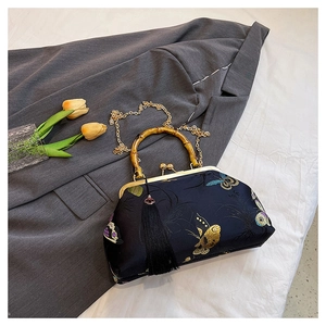Detail of dark blue vintage handbag with butterfly embroidery and bamboo handle