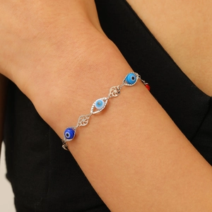 Vue détaillée d'un bracelet en chaîne argentée avec perles œil bleu sur un poignet