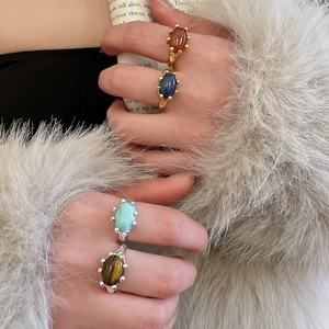 Detail of vintage oval stone rings with gold and silver plating on fur cuff