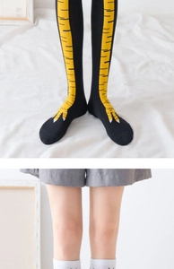 Detail of creative chicken feet knee high socks with yellow patterns on black fabric