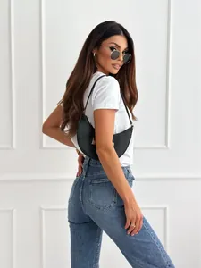 Detail of white V-neck T-shirt paired with rhinestone jeans and a black crescent bag