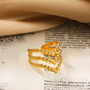 Detailopname van een gouden drielaagse V-ring met kralen op vintage achtergrond