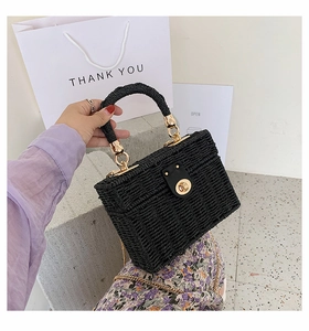 Detail der schwarzen gewebten Box-Tasche mit goldenen Details und klobigem Griff
