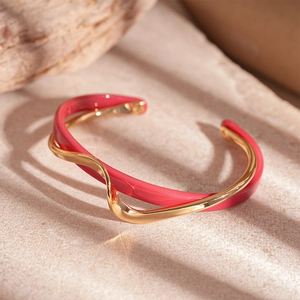 Detail of gold-plated wavy double-layer cuff bracelet with rose red enamel finish