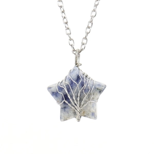 Macro detail of star-shaped sodalite pendant with silver tree of life wire wrapping