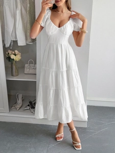 Abito lungo bianco con maniche a sbuffo, scollo a V e gonna a balze su modella