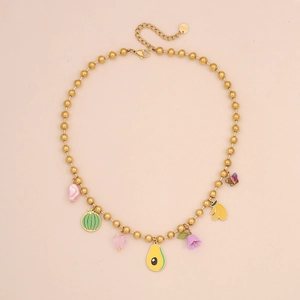 Detail of beaded necklace with fruit charms and S.STEEL stamp on pink background