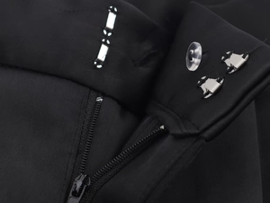 Dettaglio macro dei pantaloni in raso nero con cerniera e chiusura con gancio metallico