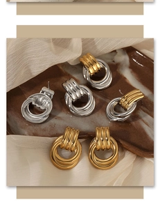 Detailed view of intertwined triple-ring earrings in gold, silver, and mixed tones