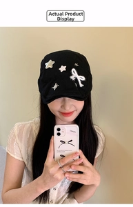 Detail of black beret with silver star patches and white fringe bow decoration