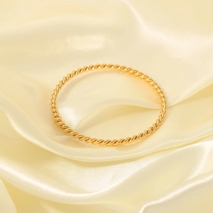 Classic 18K gold plated stainless steel twisted rope bangle on elegant beige silk fabric