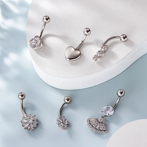 Set of 6 stainless steel belly rings with heart and flower zircon designs on white blocks