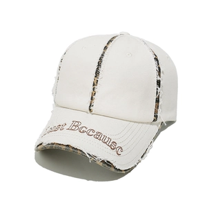 Detail of white cotton baseball cap with leopard print trim and Just Because embroidery