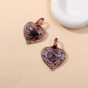 Detailed macro view of purple heart glass pendants with delicate internal flower textures