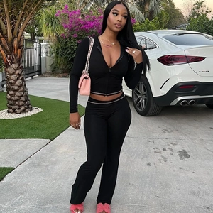 Detail of black hooded zip-up crop top and matching leggings on a model outdoors