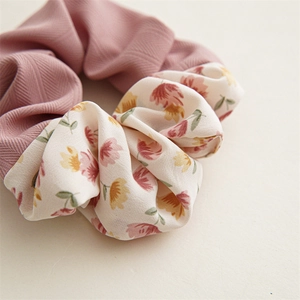 Close-up detail of a floral scrunchie with pink fabric and stitching textures
