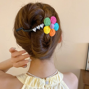 Gros plan d'une pince à cheveux fleurs tissées colorées avec strass sur les cheveux